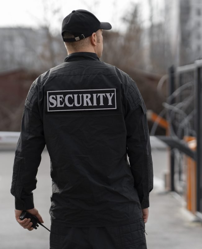 portrait-male-security-guard-with-barbed-wire-fence